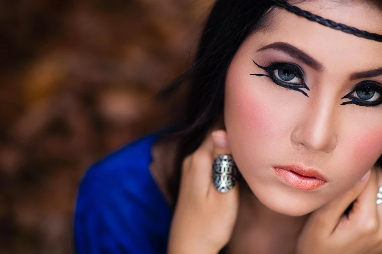 a woman wearing rings on her fingers poses for a po