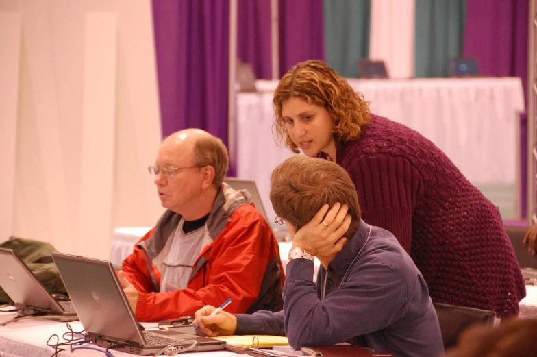 people at an event with laptop computers and one on his head