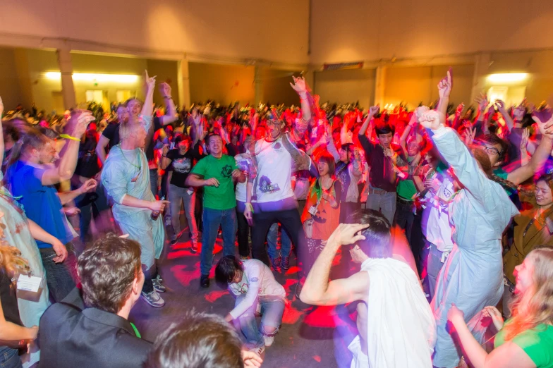 group of people dancing together on the dance floor