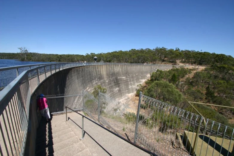 a woman is on stairs near a dam