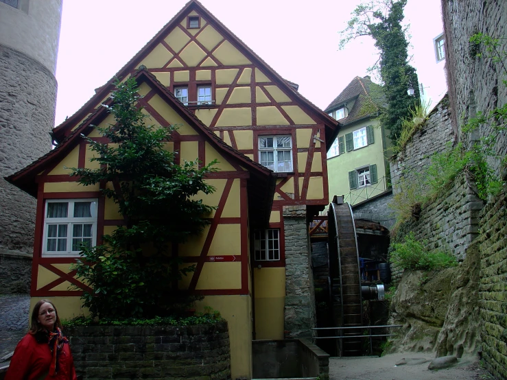 a woman is in front of a half - timbered building