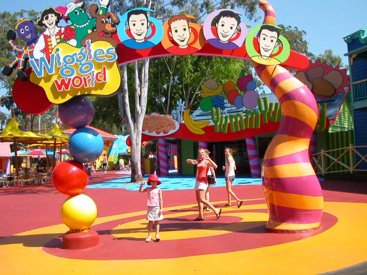 children walking around in front of a wiggly world sign