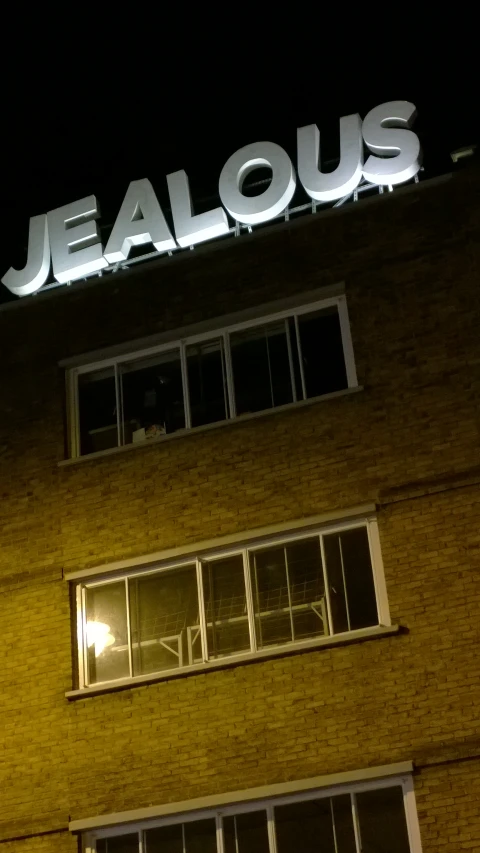 the word jellous is lit on the side of the building