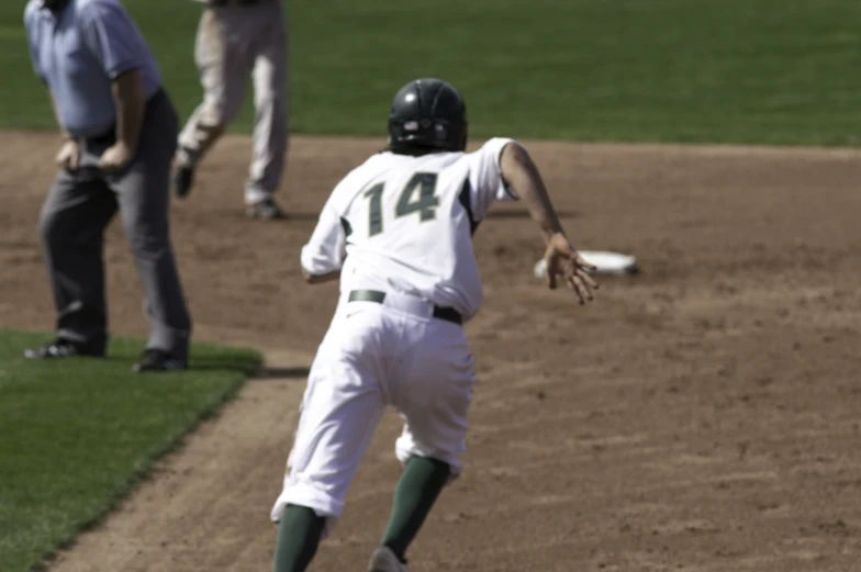 the baseball player is catching a ball that is flying