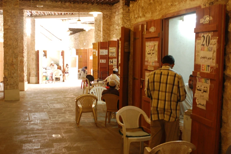 there are people walking by a store with tables and chairs