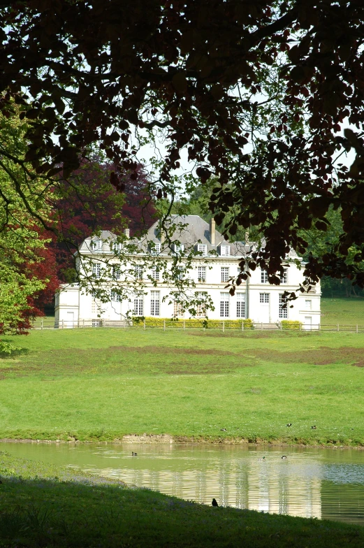 the exterior of a house next to a pond