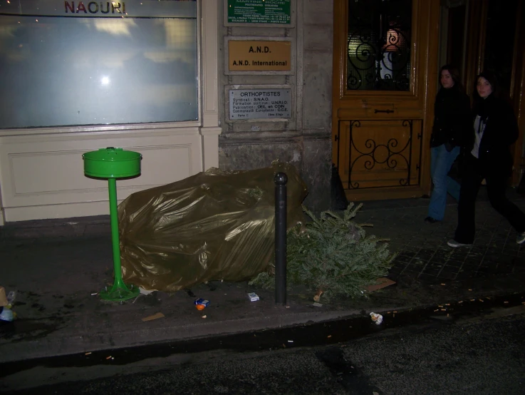 the trash is near the green table outside