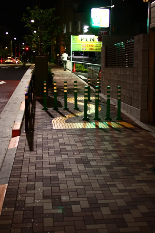 the street has several small green and yellow posts on it