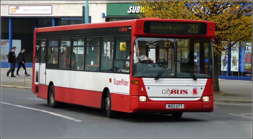 a bus with red and white stripes in the city