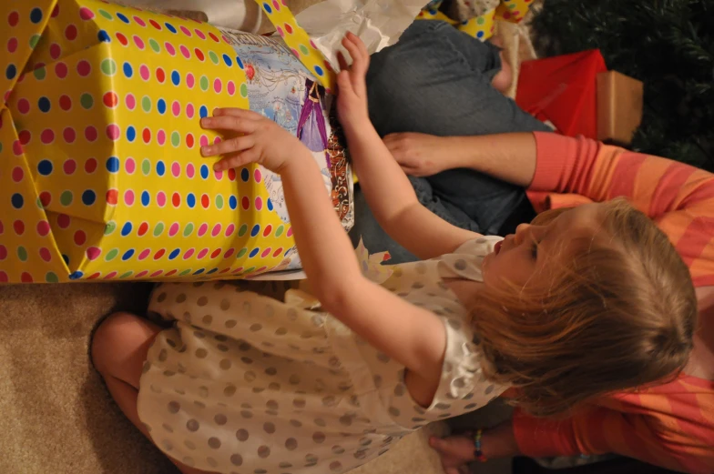 little girl looking at a large wrapped gift
