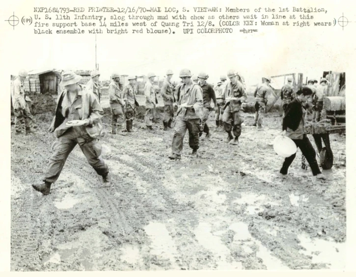 a group of men walking in a field with an open umbrella