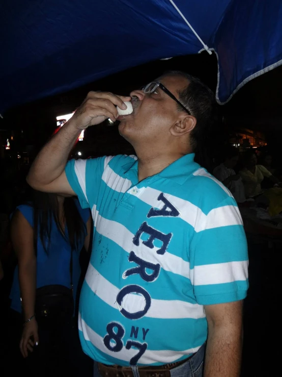 a man in glasses standing under an umbrella