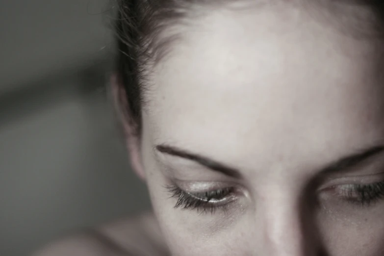 a young woman stares down with her eyes wide open