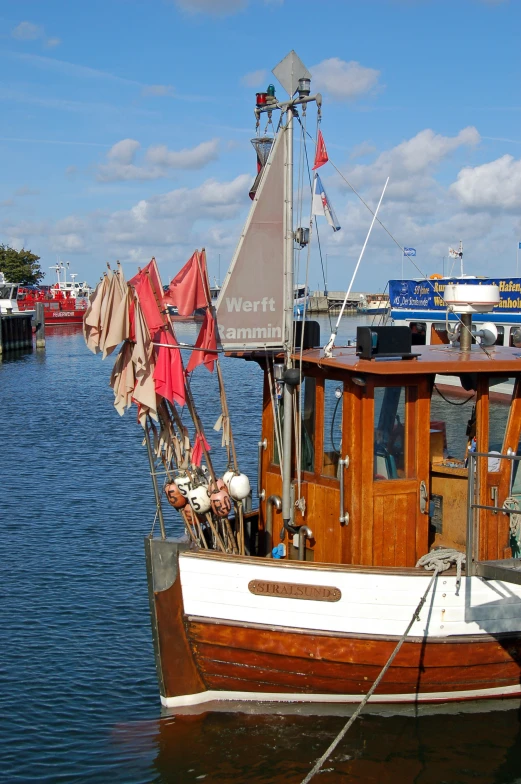 the fishing boat has sail flags on its stern