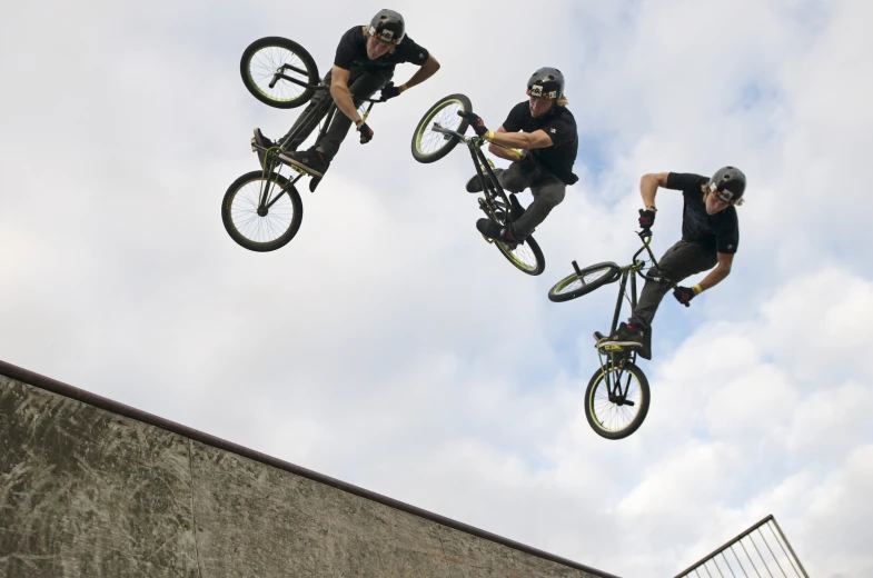 the bmx bike rider is jumping over the wall