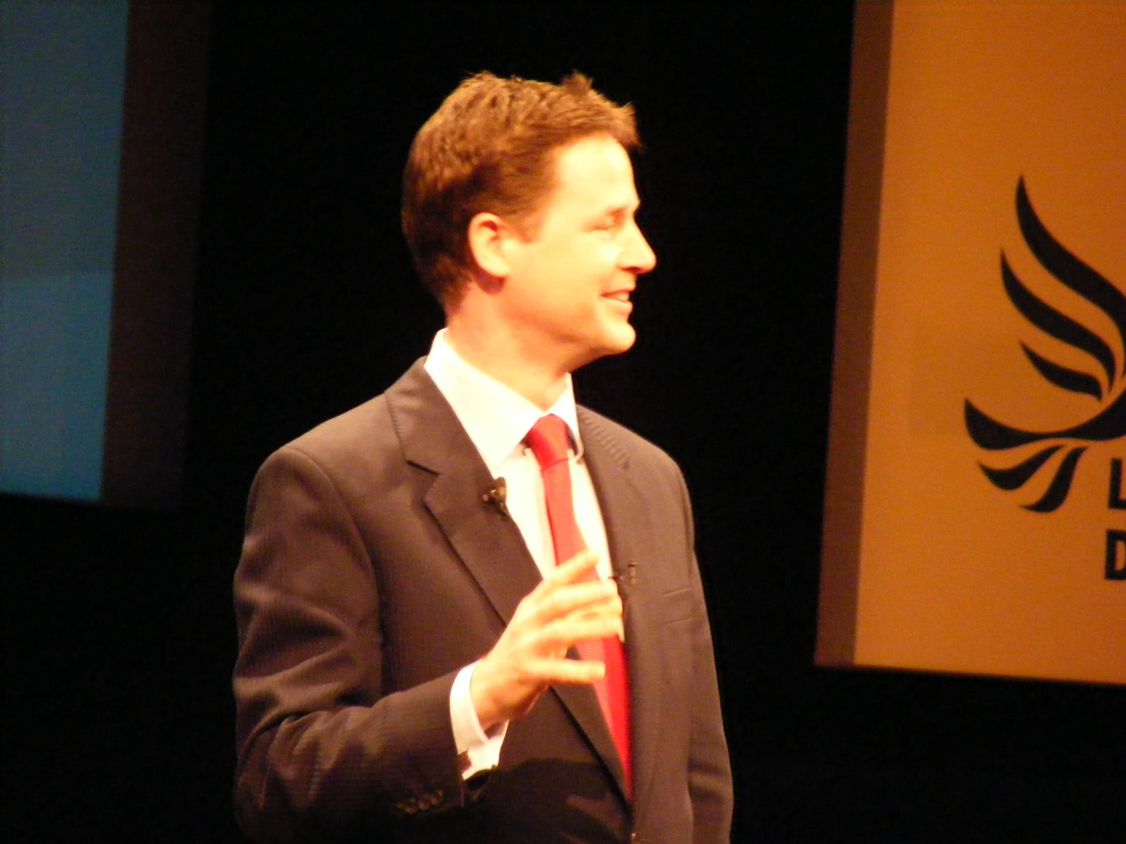 a man in a suit is giving a speech