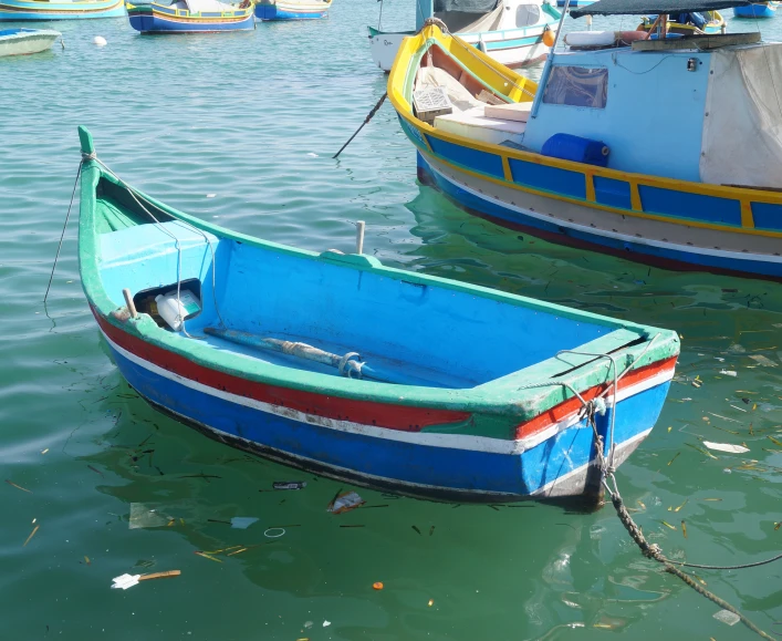 several boats in the water with blue and red one boat