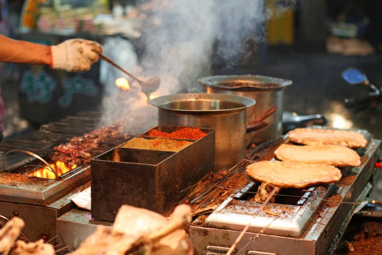 a man cooks food over a small barbecue