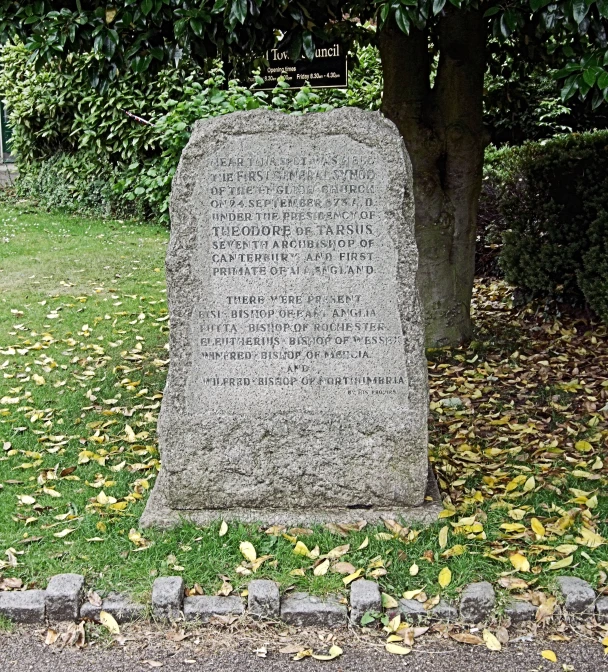 a large granite stone grave next to a small tree