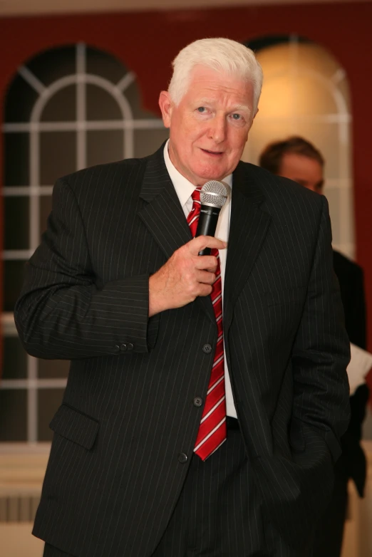 a man wearing a suit and tie holding a microphone