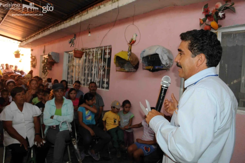 a group of people gathered together while a man speaks to them