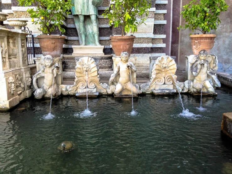 a statue and fountains at a small outdoor swimming pool