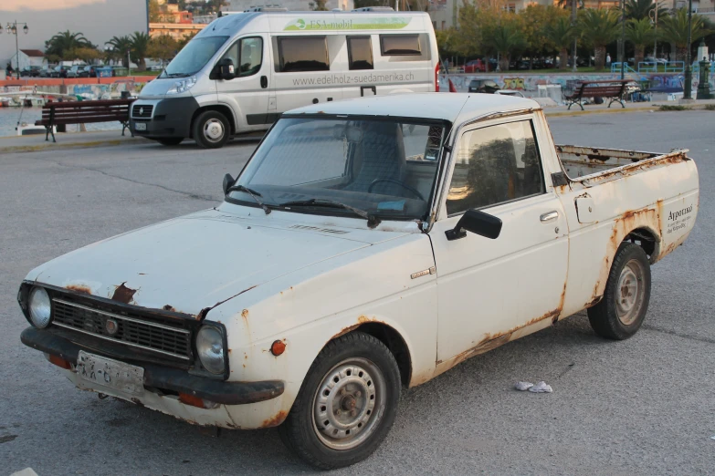 an old dirty truck is parked in a parking lot