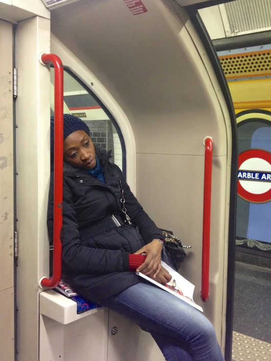 a woman sitting on the inside of a public transit train