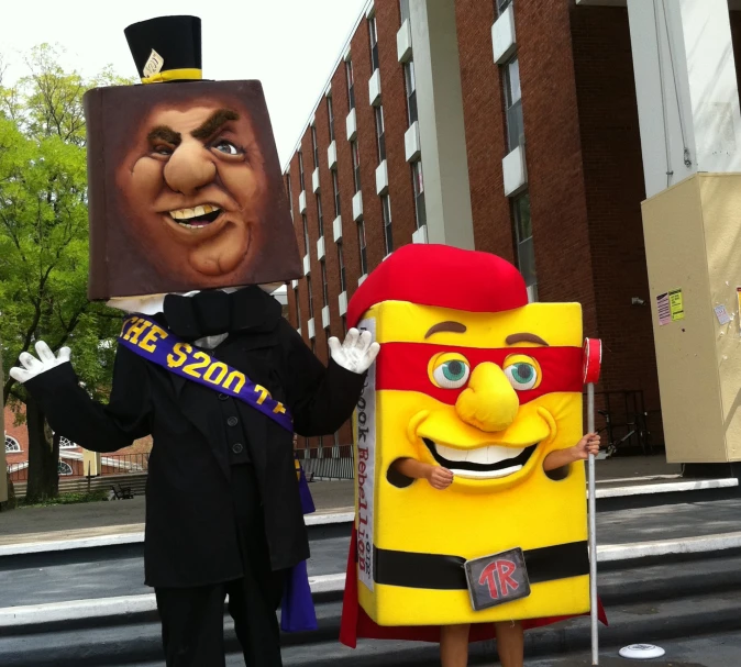 a man in costume next to a giant cartoon character