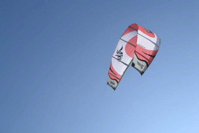 a person flies a red and white kite