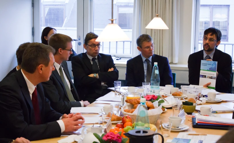 men in suits at a table with food