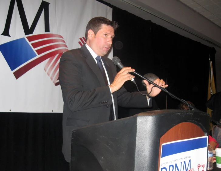 a man that is standing at a podium with microphone