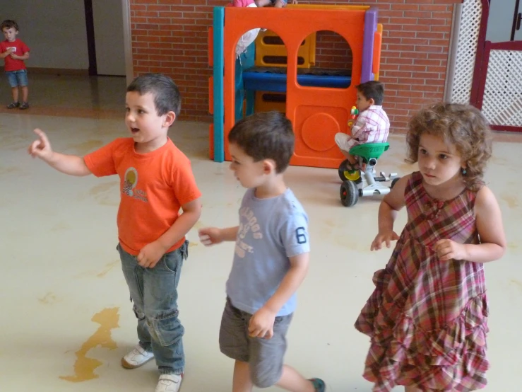 the young children are playing in a play ground