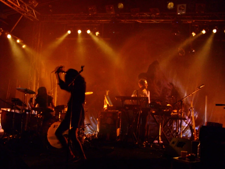 band members singing in front of stage lights