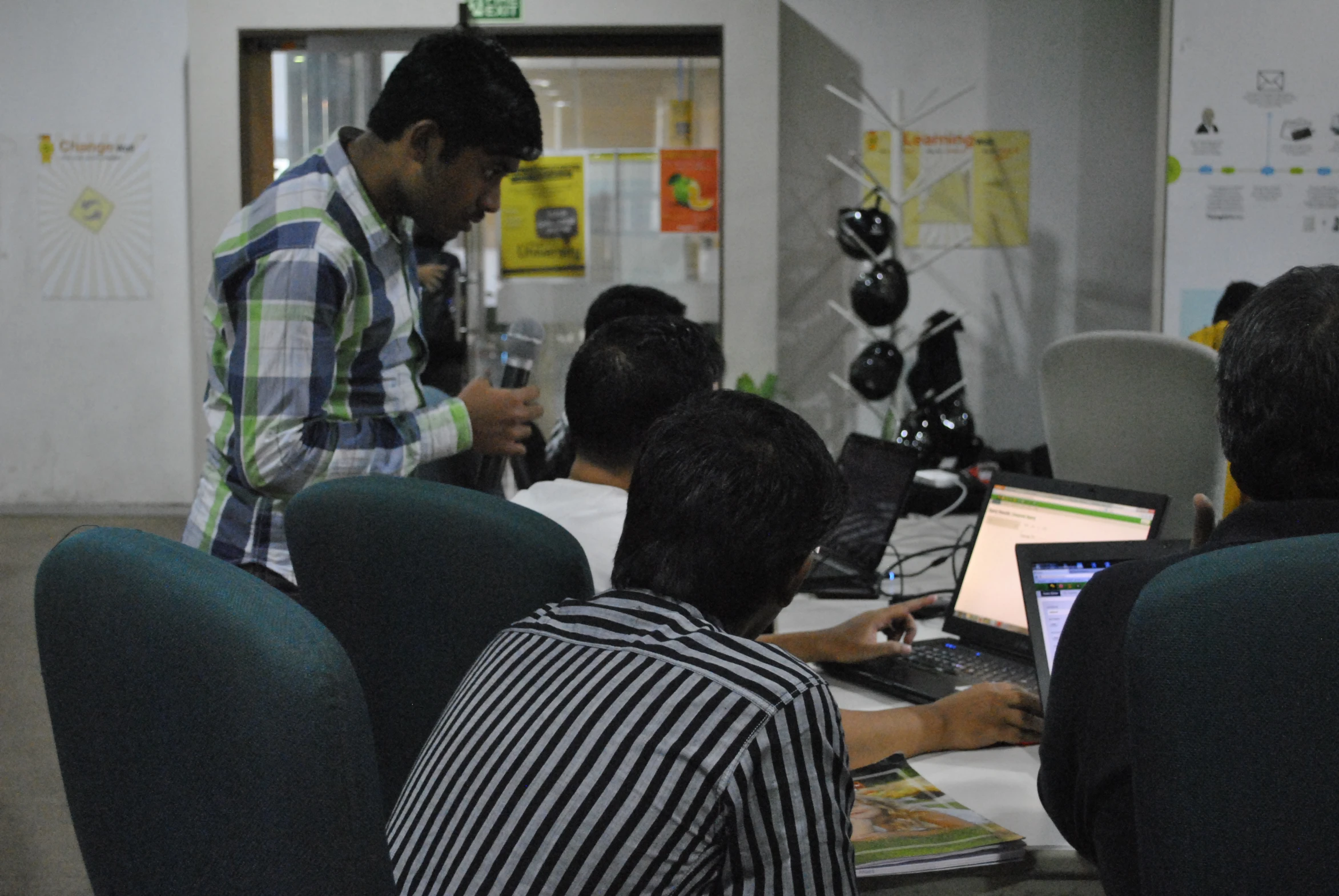 men work on computers in a cubicle with no people