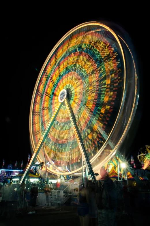 the large wheel is spinning around on the dark night