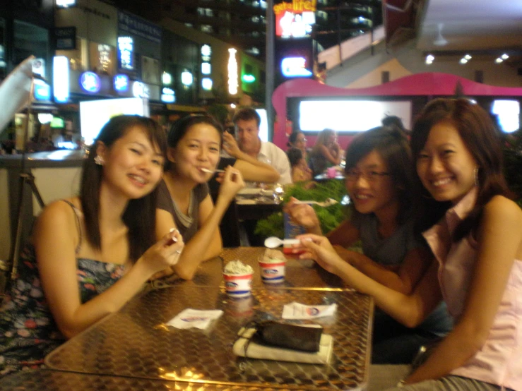 a group of girls sitting at a table having drinks