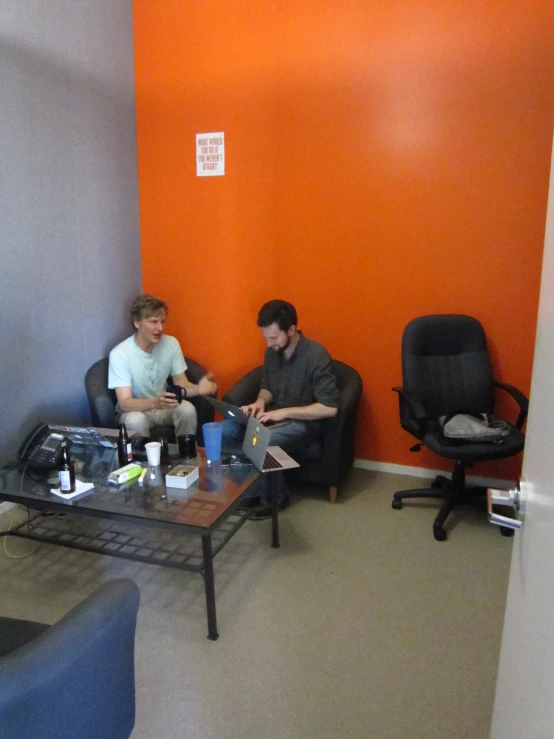 two men are sitting in chairs by a table