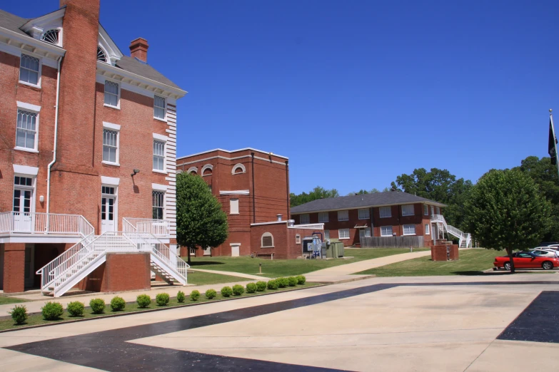 red brick building with white balconies and two story walkway to another building