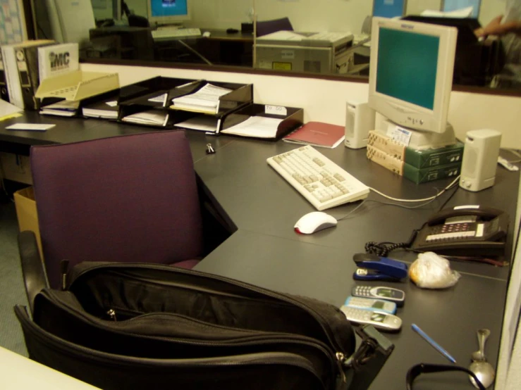 a black bag on a computer desk with a chair