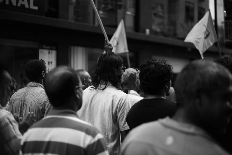 the crowd is walking on a busy street with several flags