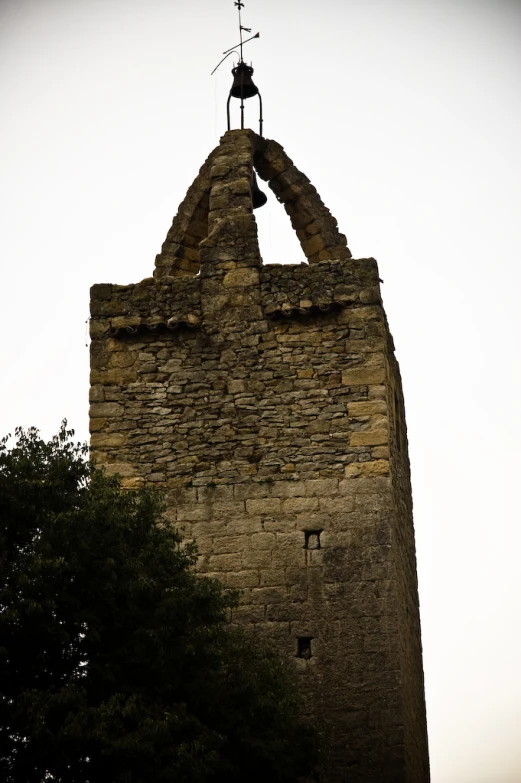 a black and white po of an old brick structure with an ancient bell