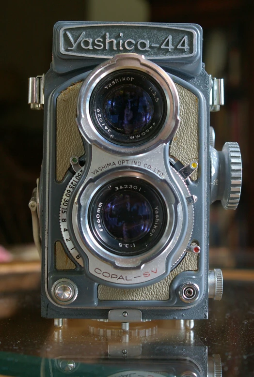 an old style camera on top of a glass table