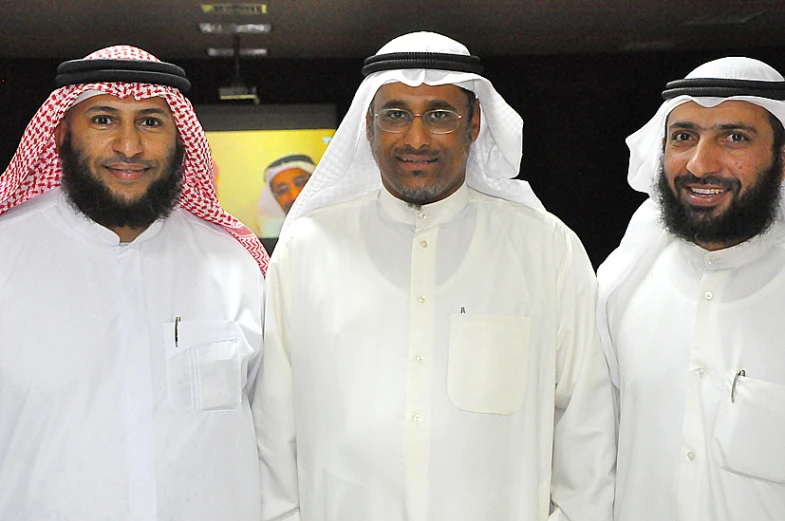 three men wearing white standing next to each other