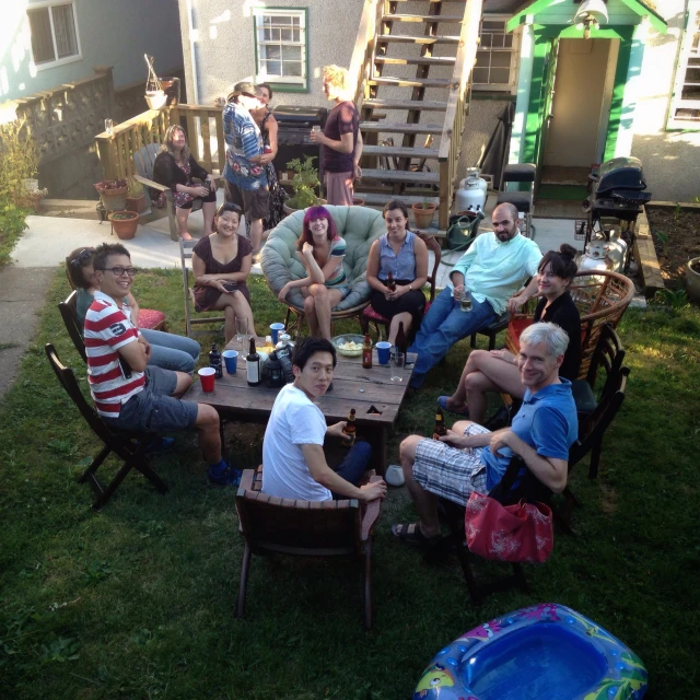 group of people sitting at wooden table on grass