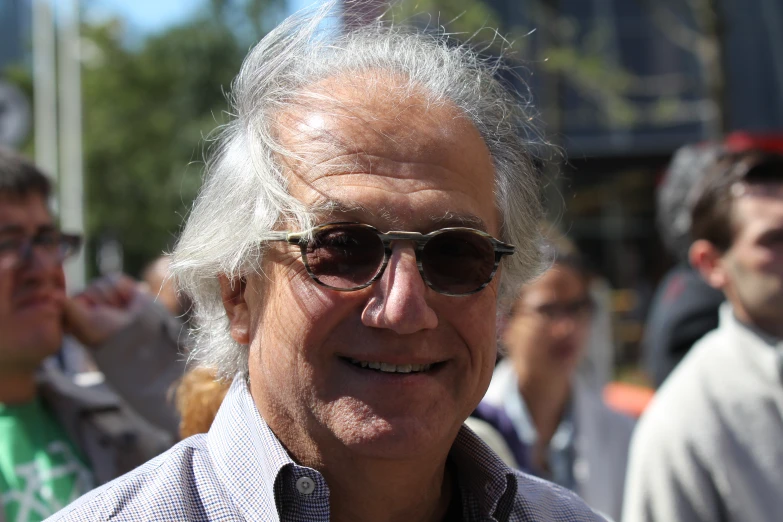 a man with gray hair wearing glasses and smiling