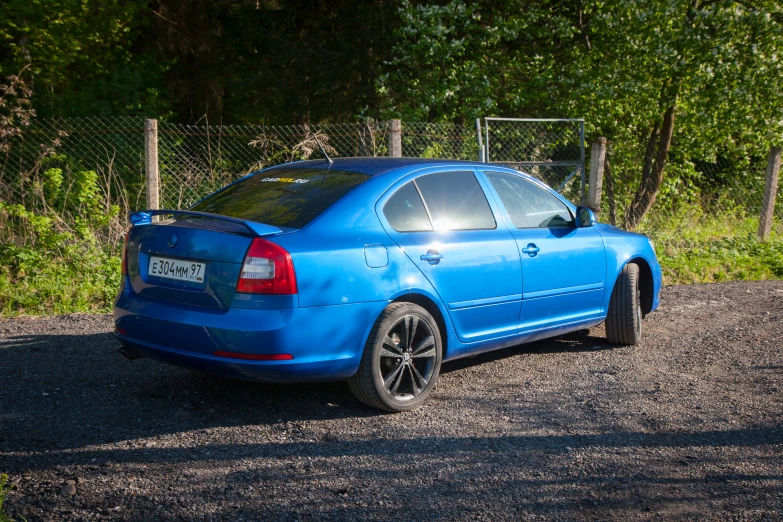 a car parked next to a fence near trees