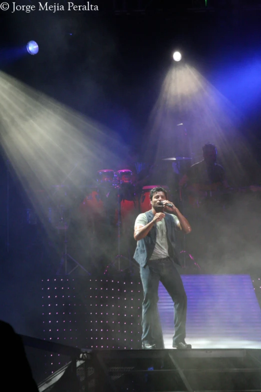 a man in front of a microphone on stage