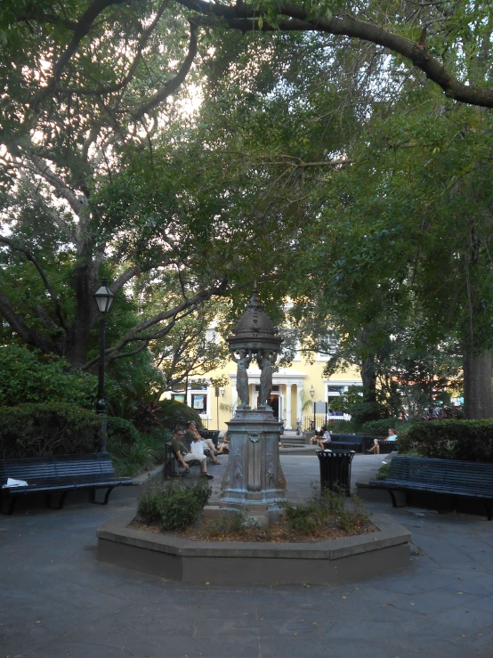 a park bench in front of a building with lots of trees