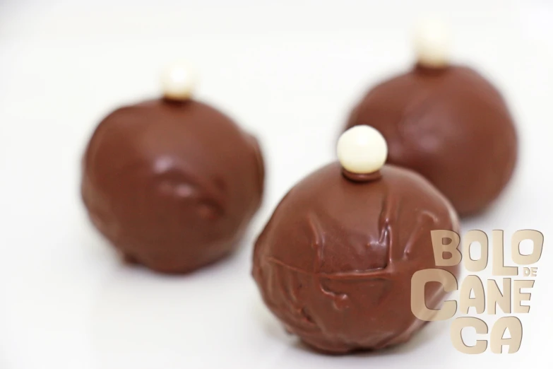 three chocolate candy candies in a line on a white background